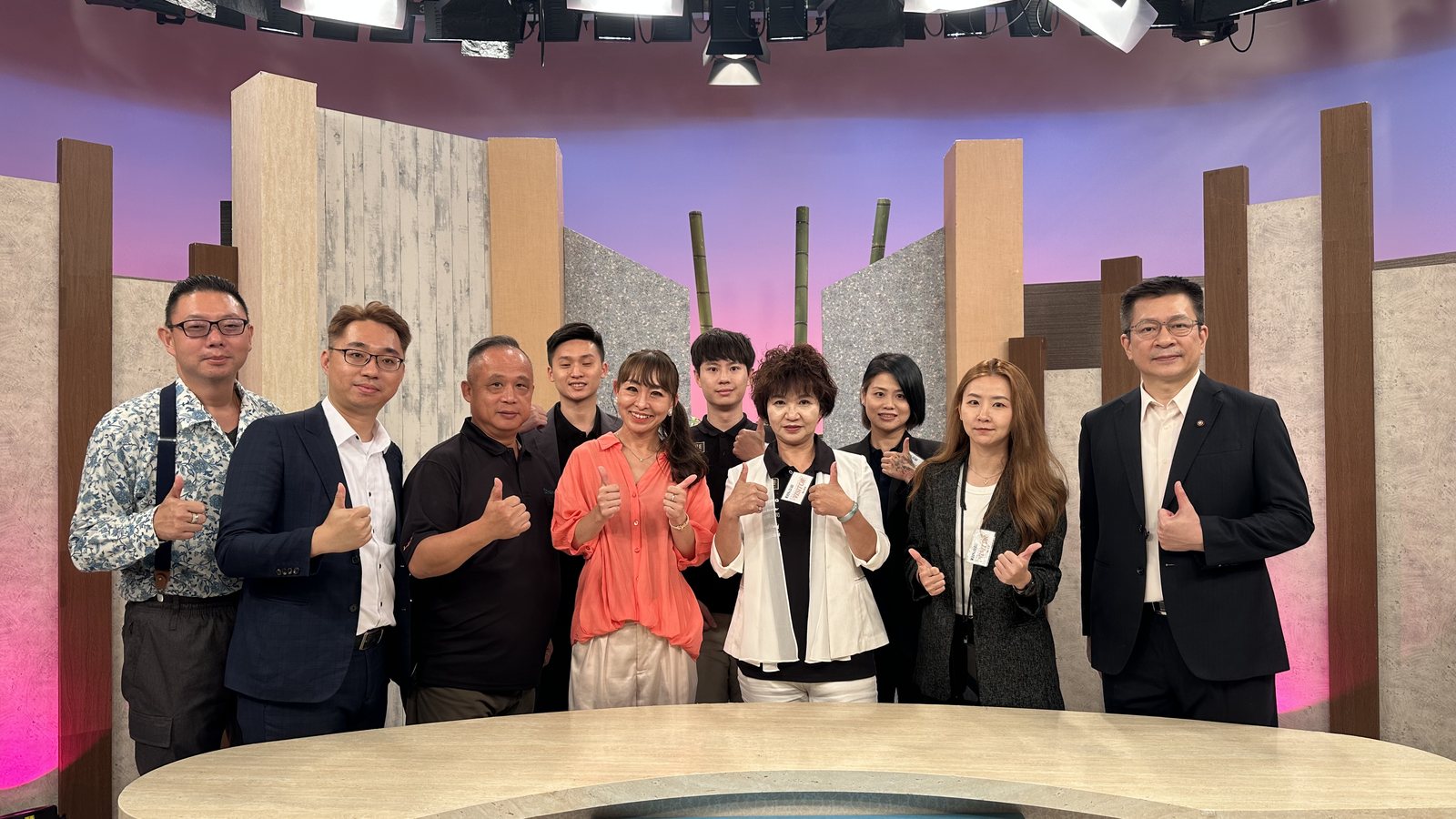 團隊與節目主持人於主播檯合影